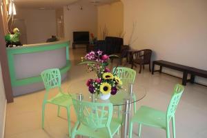 une table et des chaises avec un vase de fleurs. dans l'établissement Hotel Kawan, à Tapah
