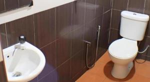 ein Badezimmer mit Toilette und Waschbecken in der Unterkunft Taipann Hotel in Kampong Telok Gadong Besar