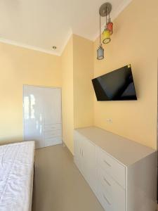a bedroom with a bed and a flat screen tv on the wall at Amlana villa in Gili Trawangan