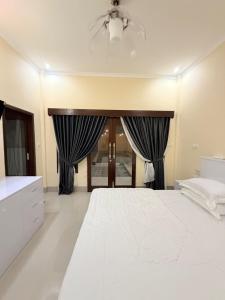 a bedroom with a white bed and black curtains at Amlana villa in Gili Trawangan +24 photos