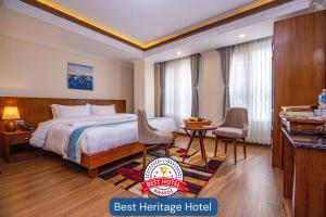 a hotel room with a bed and a table and chairs at Darbar Heritage Inn in Kathmandu
