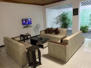 a living room with two couches and a tv at JHome in Kurunegala