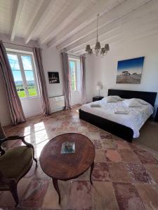 een slaapkamer met een bed en een salontafel bij La maison de l'Architecte - Gite proche Bordeaux in Salleboeuf