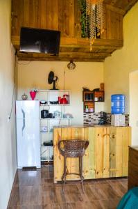 a kitchen with a white refrigerator and a chair at Casa clima da montanha 1 in Cunha
