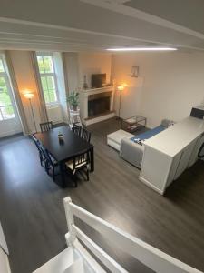 een woonkamer met een bed, een tafel en een bank bij La maison de l'Architecte - Gite proche Bordeaux in Salleboeuf