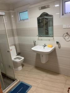 a bathroom with a sink and a toilet and a mirror at JHome in Kurunegala +30 photos