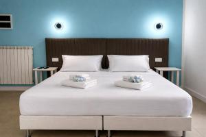 ein großes weißes Bett mit zwei Kissen darauf in der Unterkunft Hotel Cantore in Genua
