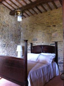 a bedroom with a bed in a stone wall at L'Infinito in Mombaroccio