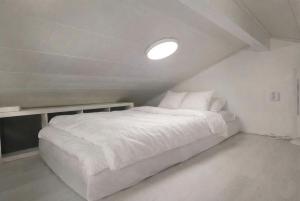 una camera da letto con un letto bianco e una luce sopra di Aurora Jukkas Lodge 2 - Arctic Suite a Jukkasjärvi
