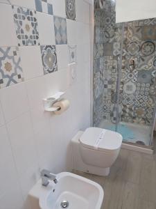 a bathroom with a toilet and a shower and a sink at Domus Battisti in Caserta