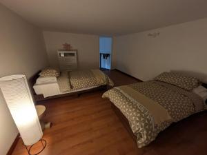 a bedroom with two beds and a lamp in it at Domus Battisti in Caserta