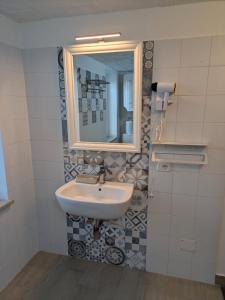 a bathroom with a sink and a mirror at Domus Battisti in Caserta +2 photos