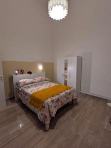 a bedroom with a bed and a chandelier at Domus Battisti in Caserta