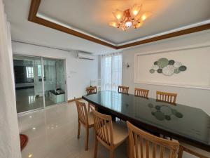 a dining room with a glass table and chairs at Cozy Stay in Ban Nong Waeng