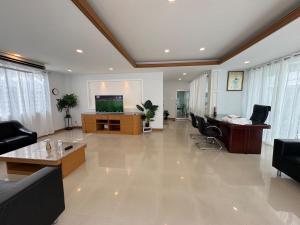 a large room with a lobby with chairs and a television at Cozy Stay in Ban Nong Waeng