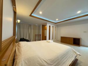 a bedroom with a large bed and a television at Cozy Stay in Ban Nong Waeng