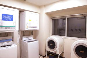 uma lavandaria com máquinas de lavar roupa e uma janela em Kuretake Inn Asahikawa em Asahikawa