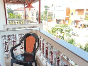 a chair sitting on a balcony looking out at a street at Richnest Apartment and villas Colva in Colva