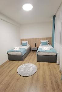 twee bedden in een kamer met een houten vloer bij Карина - къща за гости in Ognyanovo +21 foto's