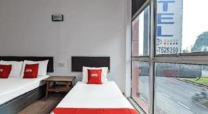 een slaapkamer met 2 bedden met rode kussens en een raam bij OYO 90643 Gks Hotel in Seremban