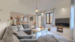 een woonkamer met een bank en een tv bij Rustic villa Pietro with panoramic view in Motovun in Motovun