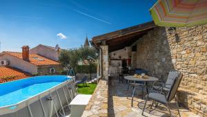 een villa met een zwembad en een patio bij Rustic villa Pietro with panoramic view in Motovun in Motovun