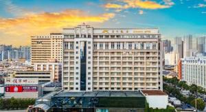 een groot wit gebouw in een stad met gebouwen bij Kunming Hotel in Kunming