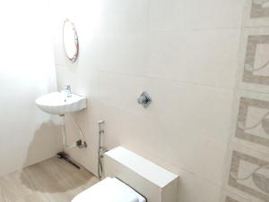 a white bathroom with a toilet and a sink at Richnest Apartment and villas Colva in Colva +38 photos