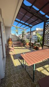 eine Terrasse mit einem Tisch und Bänken auf einem Balkon in der Unterkunft Sparano Top Class 7 in Bari