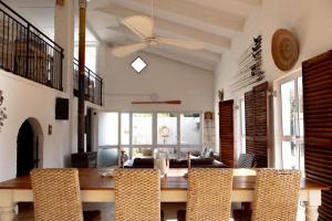 a dining room with a ceiling fan and a table and chairs at Joan's Sea Cottage in Pringle Bay