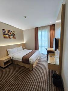 古晋DeHome Boutique Hotel的一间配有床和平板电视的酒店房间