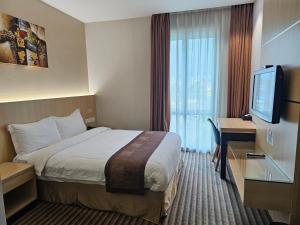 古晋DeHome Boutique Hotel的一间配有床和平板电视的酒店房间 更多44张照片