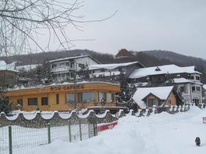 una casa en la nieve con una valla en Complex Caprice-Monteoru, en Sărata-Monteoru