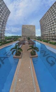 a large swimming pool with two tall buildings at Eden Living - Cebu in Lapu Lapu City