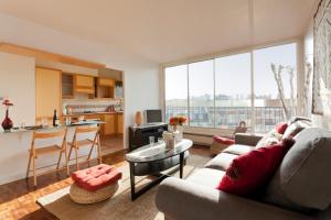 a living room with a couch and a table at Appartement le Méridien in Paris