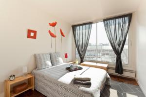 1 dormitorio con cama y ventana grande en Appartement le Méridien, en París