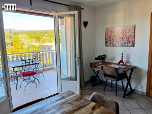 a dining room with a table and a balcony at Gîte au Ventoux in Villes-sur-Auzon