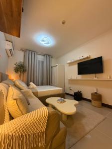a living room with a couch and a tv at Eden Living - Cebu in Lapu Lapu City