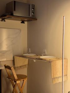 a table with two wine glasses and a microwave at Eden Living - Cebu in Lapu Lapu City
