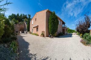 a large brick building with a gravel driveway at Gîte au Ventoux in Villes-sur-Auzon