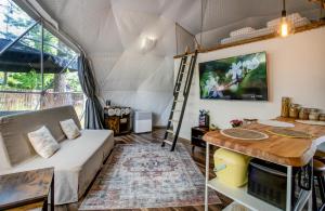 a living room with a bed and a desk and a ladder at Tiché místo Glamping in Slapy