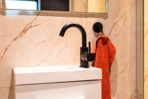 een badkamer met een wastafel en een rode handdoek bij Garnwerd aan Zee in Garnwerd +40 foto's