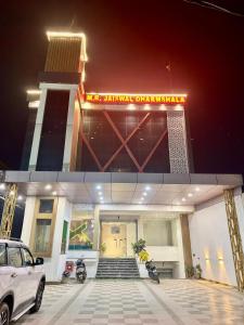 ein Gebäude mit einem davor geparkten Auto in der Unterkunft Jaiswal Dharmshala in Sultānpur