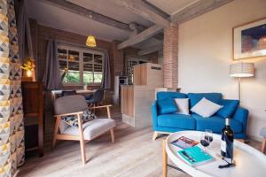 un soggiorno con un divano blu e un tavolo di La vere a Larroque