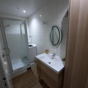 un bagno con lavandino, doccia e specchio di La vere a Larroque