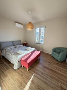 a bedroom with a bed and a couch and a window at Casa Lorà in Pistoia