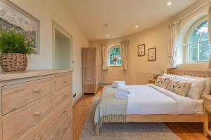 een slaapkamer met een bed, een dressoir en een raam bij Bath Lodge in Tormarton