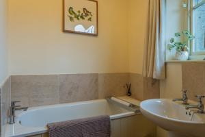 een badkamer met een ligbad en een wastafel bij Bath Lodge in Tormarton