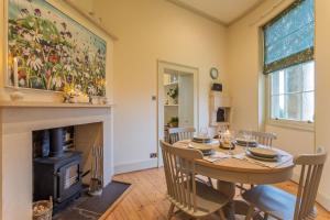 a dining room with a table and a fireplace at Bath Lodge in Bristol
