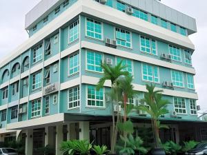 een blauw gebouw met palmbomen ervoor bij 900 Inn in Bintulu